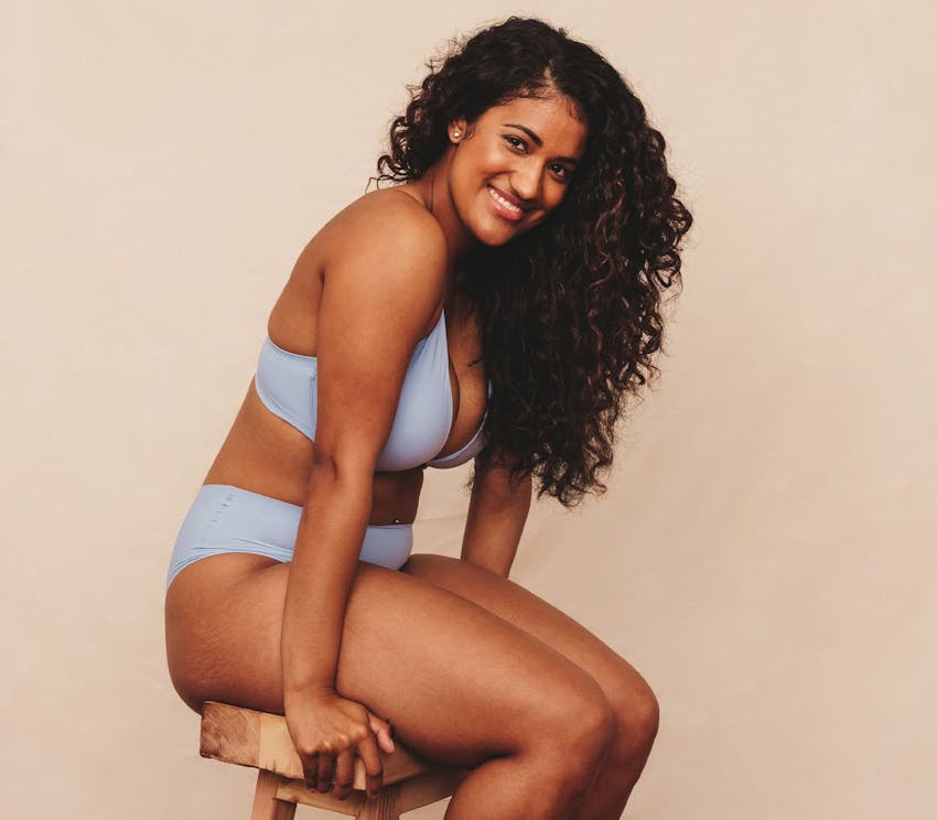 woman in underwear, sitting on a stool