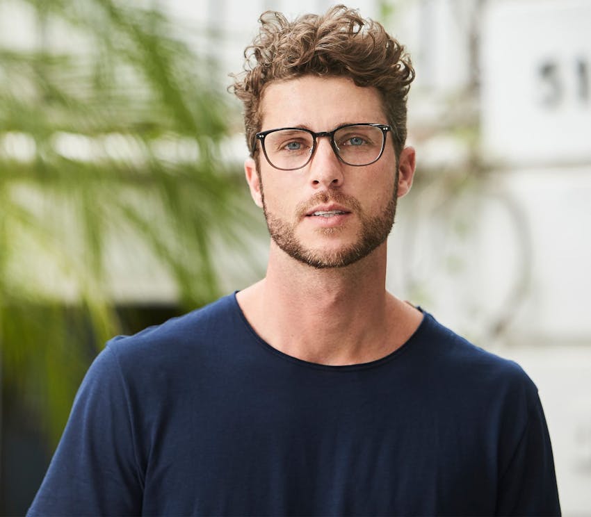 man with glasses in navy blue shirt