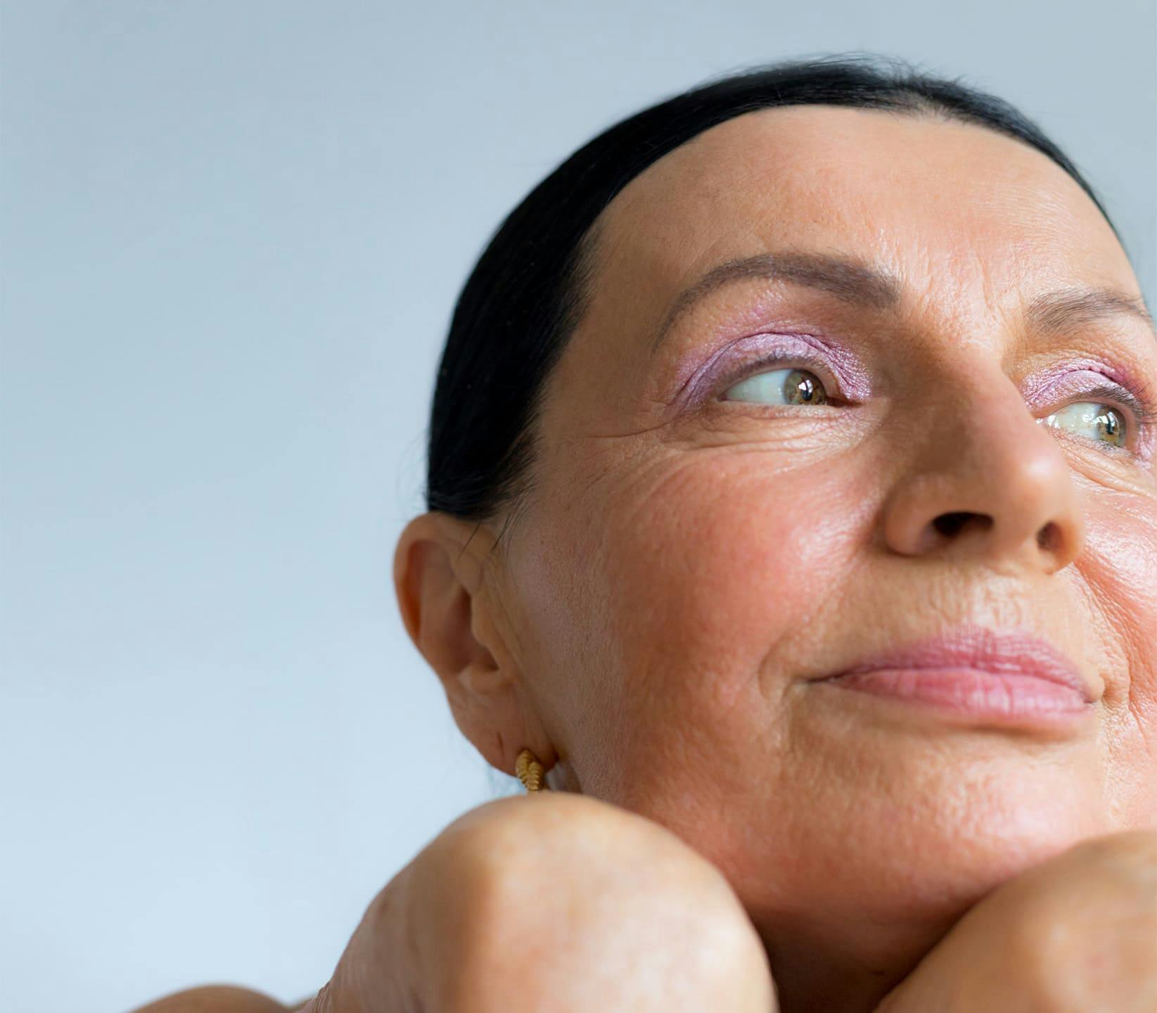 close up on older woman's face with pink eyeshadow on