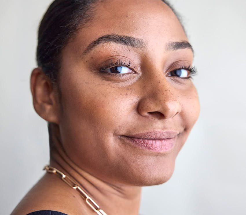 close up on woman with her hair tied up and smiling