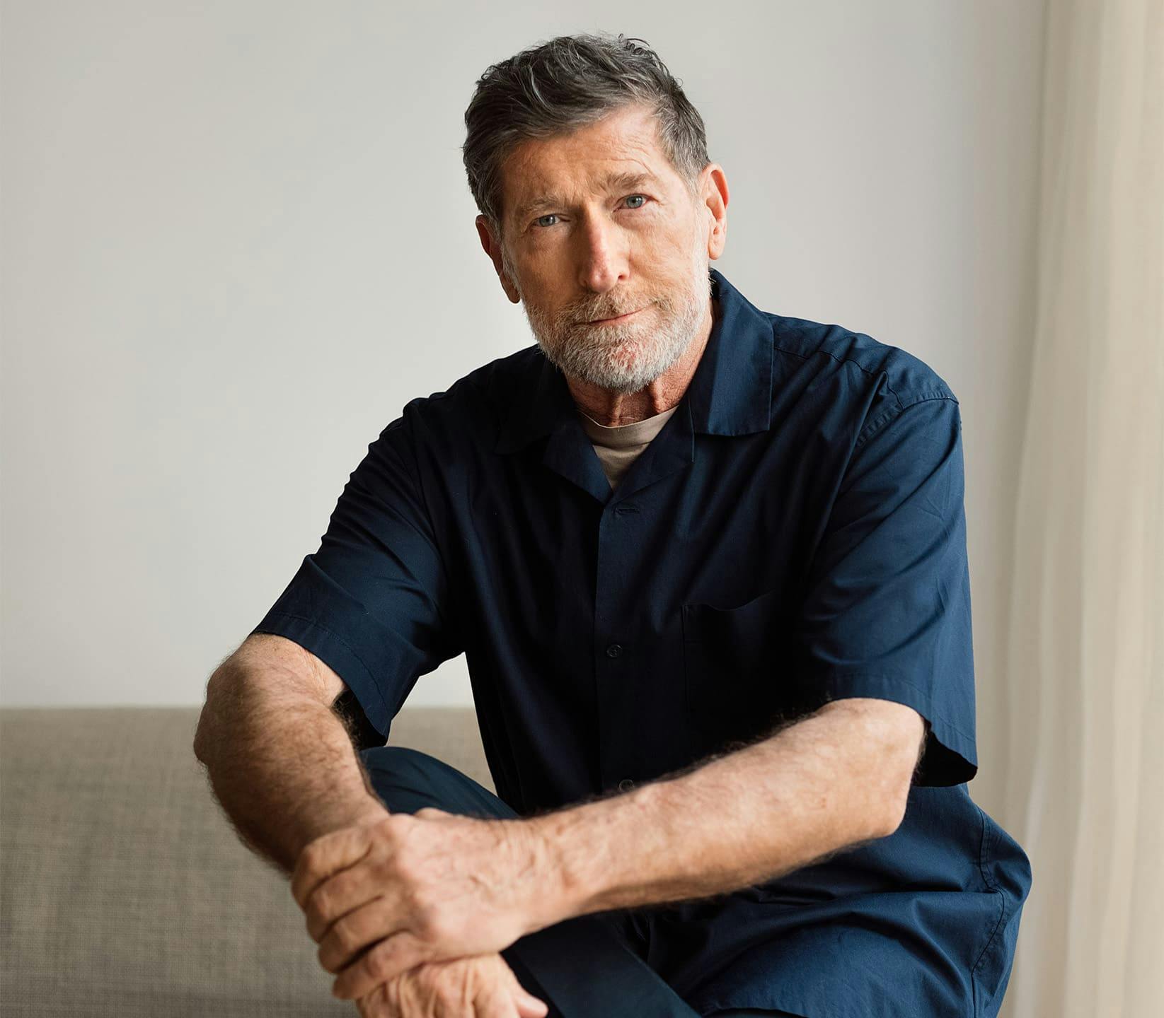 older man sitting with arm on his knee