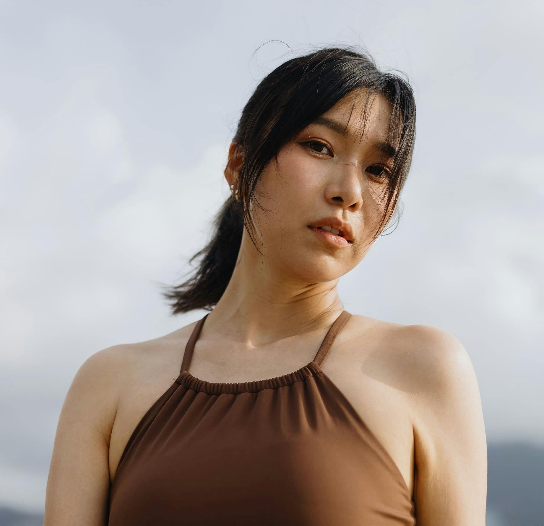 woman outside with brown top on