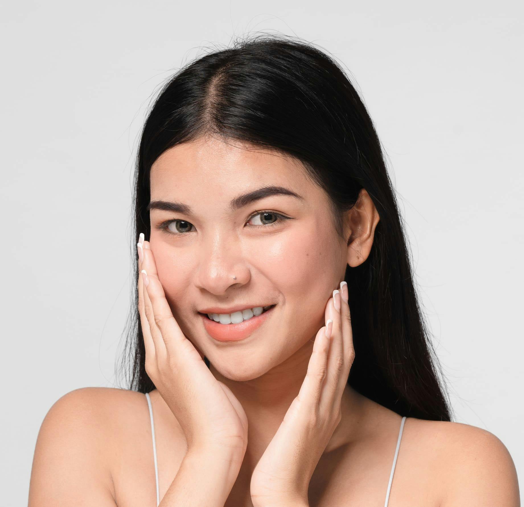 woman smiling with both hands around her face