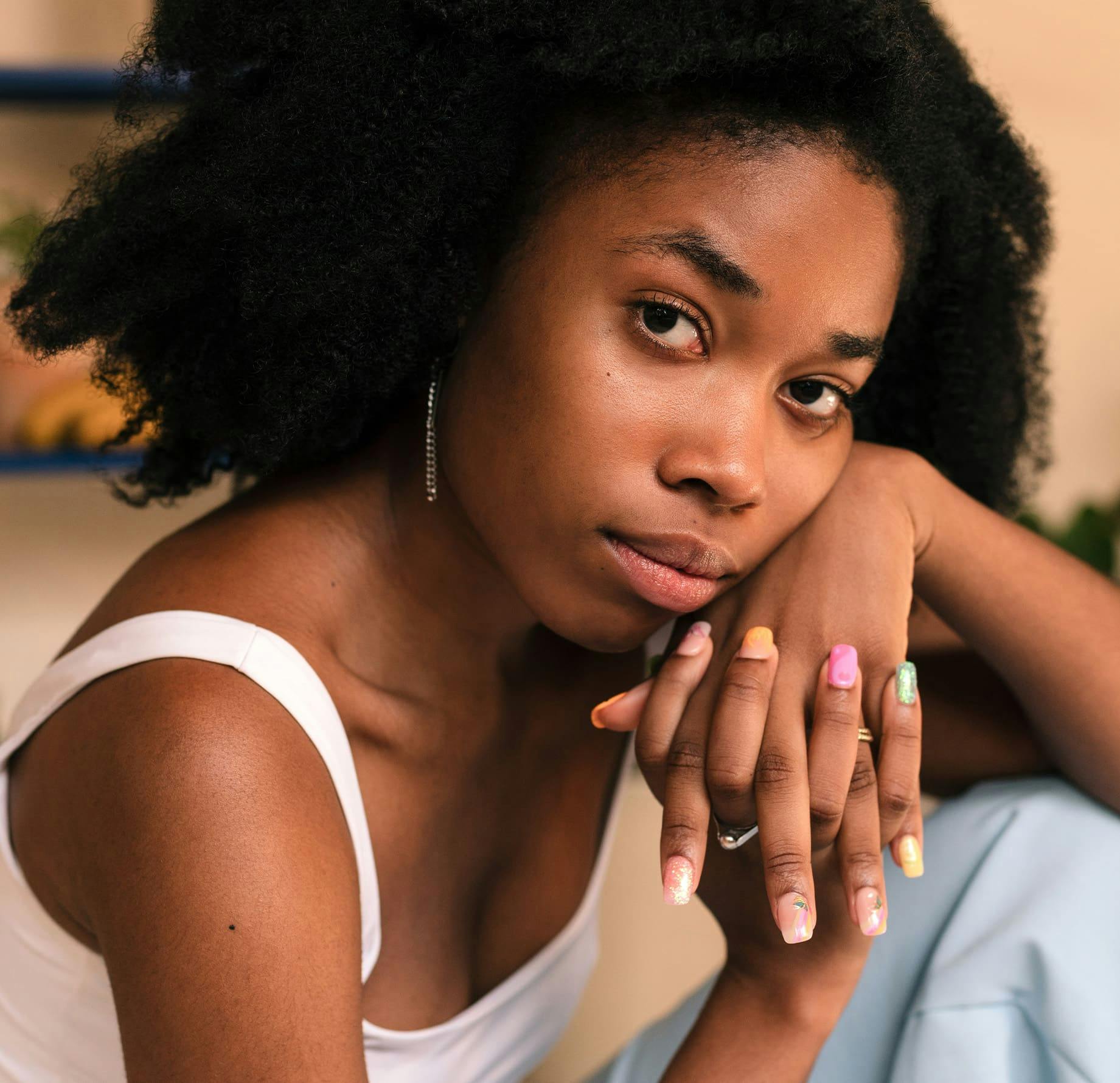 Woman with hands clasped and resting her chin on her hands