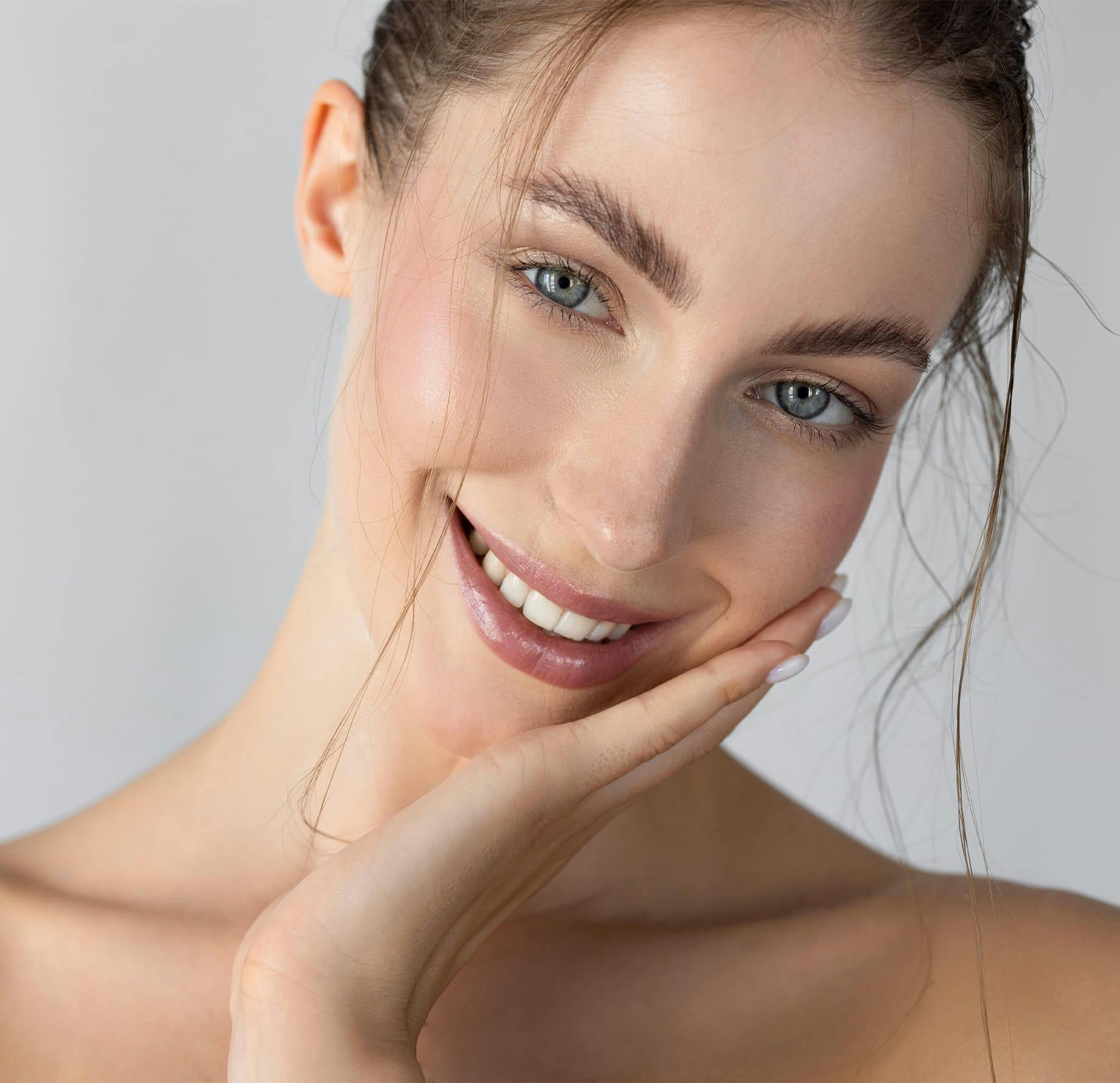 woman smiling with her hand on her cheek