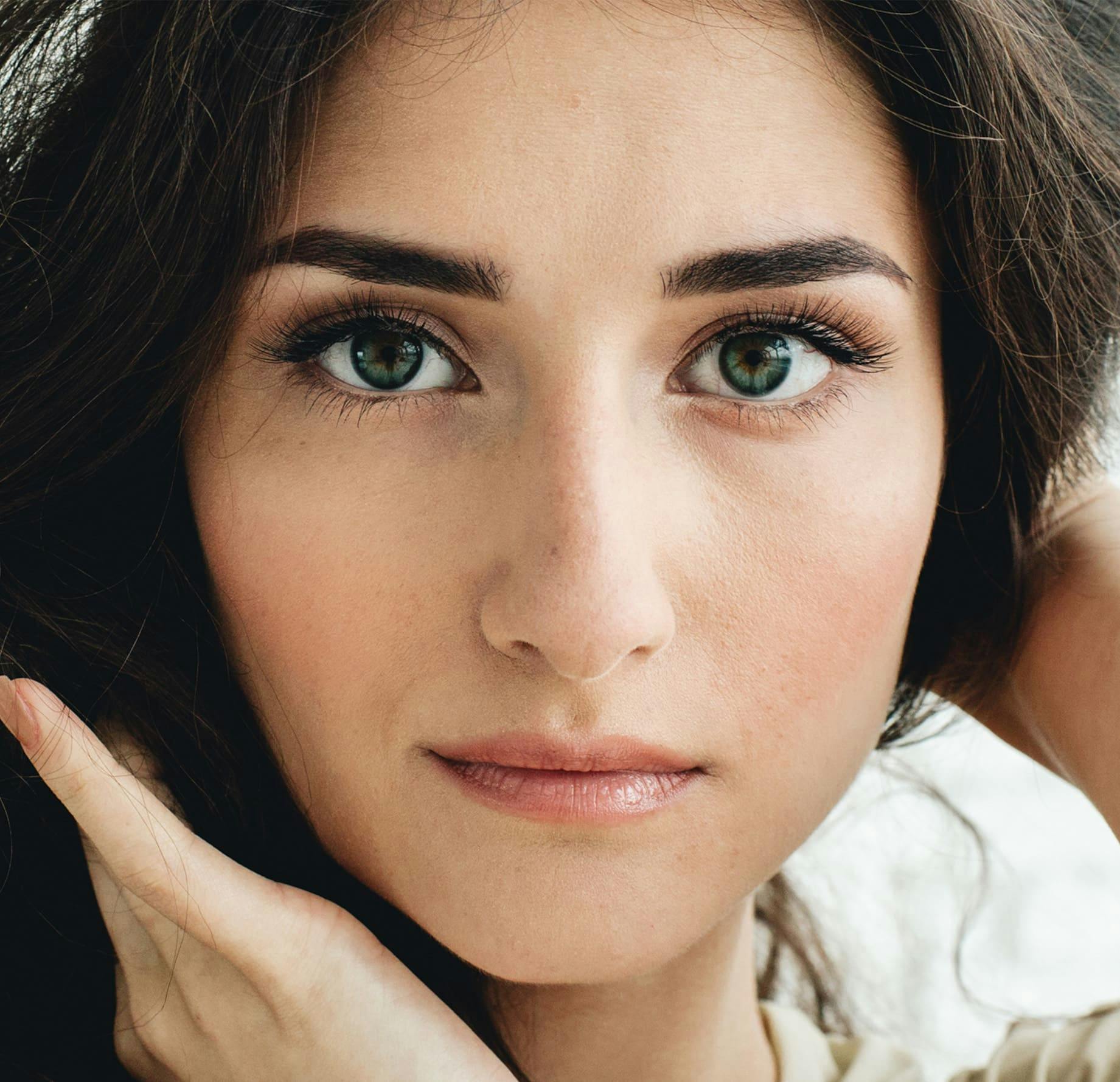 close up on woman's pale face with dark green eyes