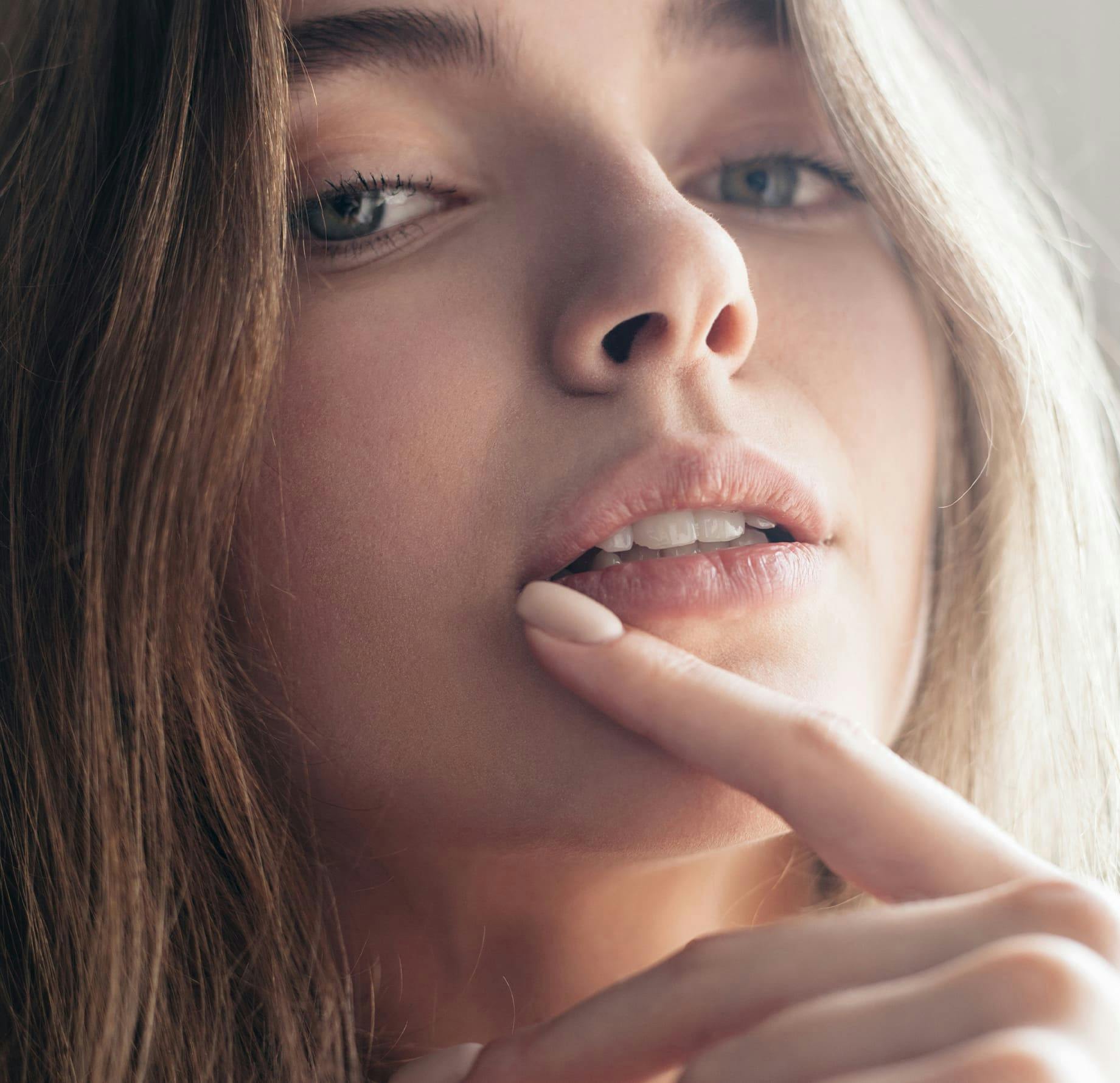 close up on woman touching the corner of her lip