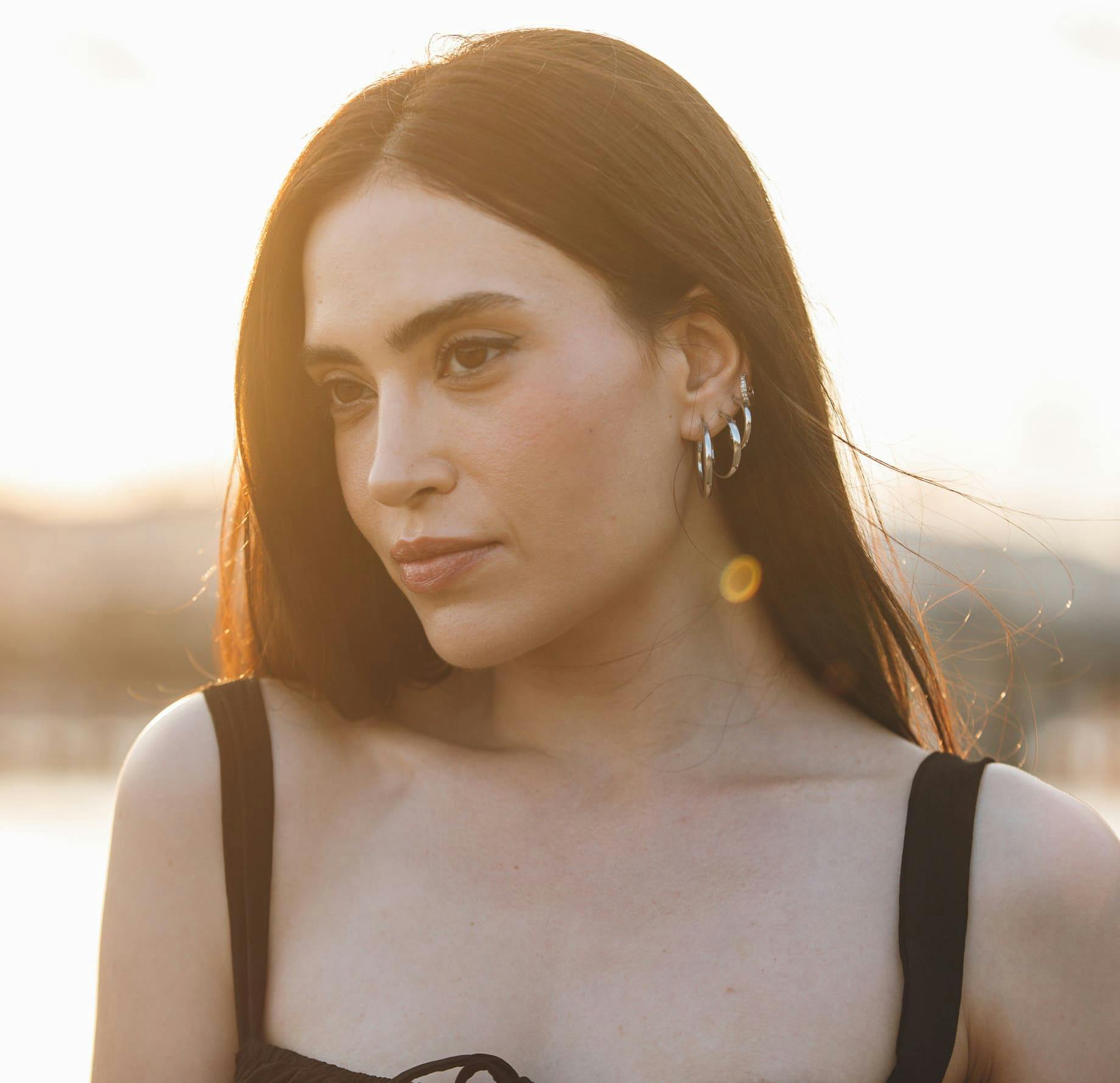 woman outside with sun setting behind her