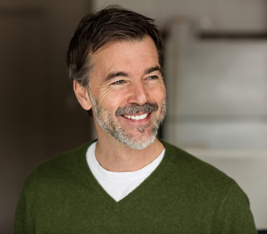 older man with light green glasses and bright yellow shirt