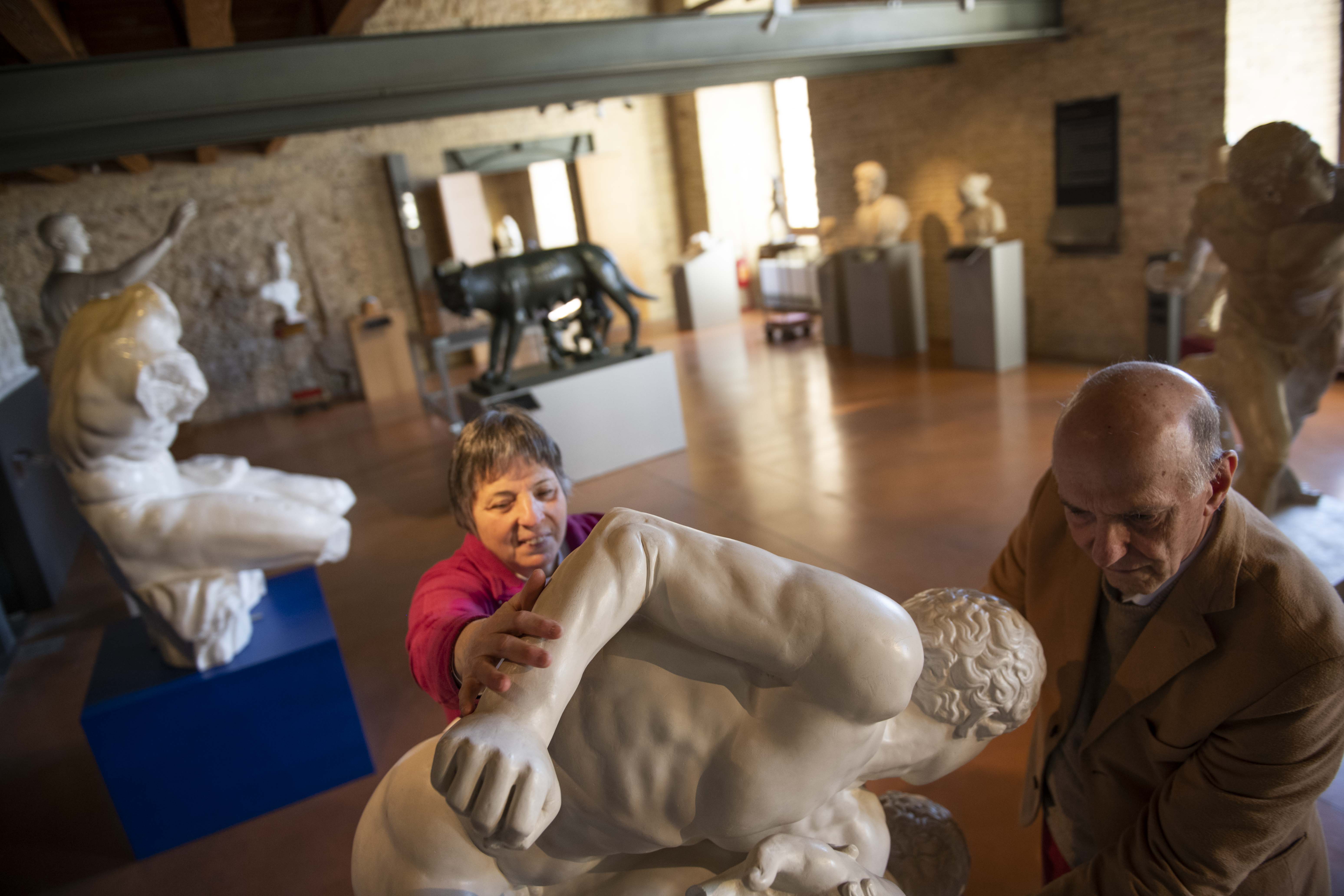 Ancona, Museo Omero. I fondatori Aldo Grassini e Daniela Bottegoni esplorano la copia in gesso de I Lottatori presso la sala greco-romana.