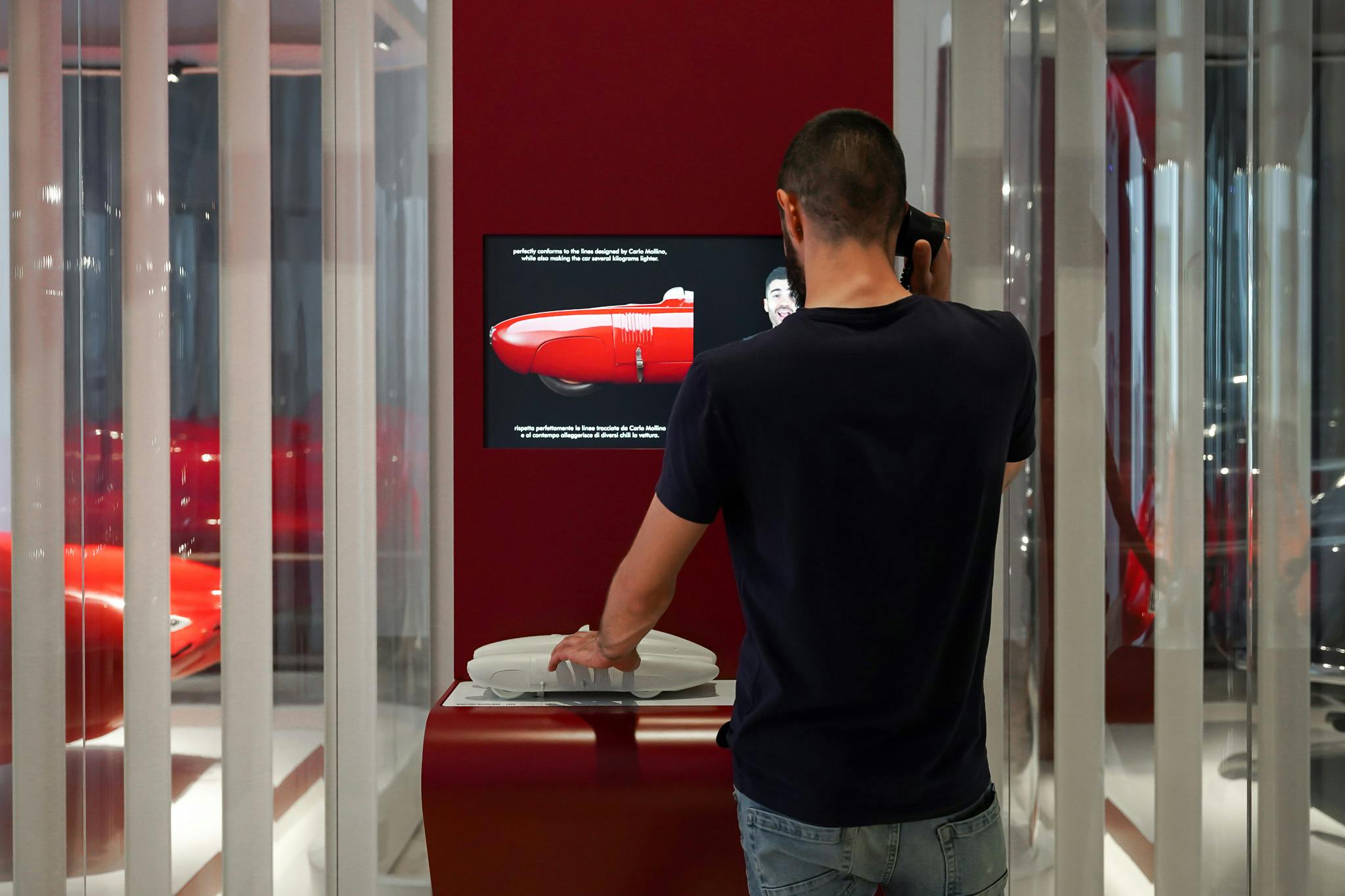 Milano, Museo della Scienza e della Tecnologia Leonardo da Vinci. Esposizione sulle auto storiche "Fatte su misura". Un uomo di spalle esplora il modello tattile tridimensionale di una delle automobili esposte.