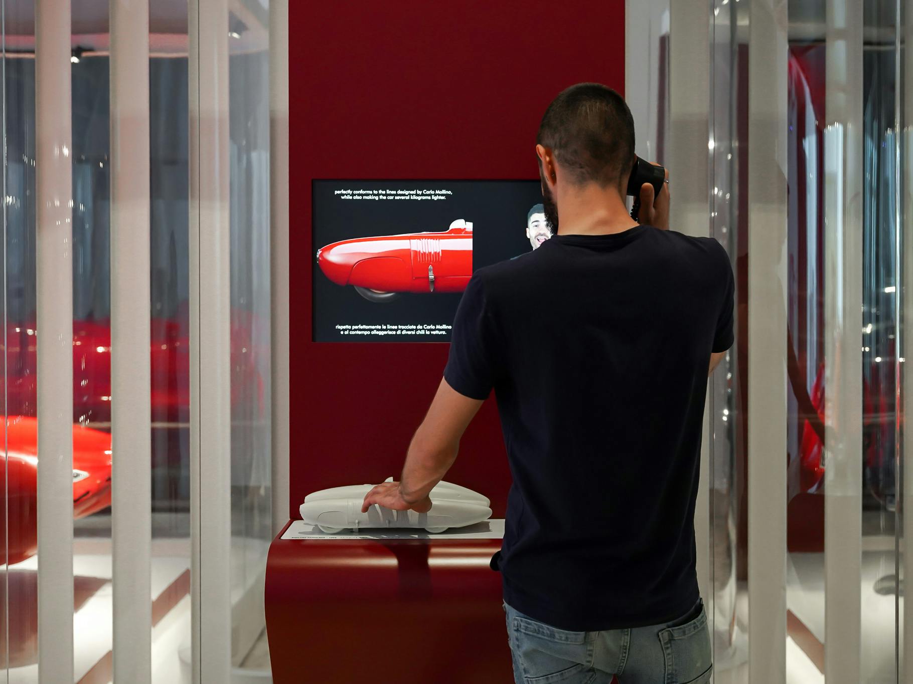 Milano, Museo della Scienza e della Tecnologia Leonardo da Vinci. Esposizione sulle auto storiche "Fatte su misura". Milano, Museo della Scienza e della Tecnologia Leonardo da Vinci. Esposizione sulle auto storiche "Fatte su misura". Un uomo di spalle esplora il modello tattile tridimensionale di una delle automobili esposte.