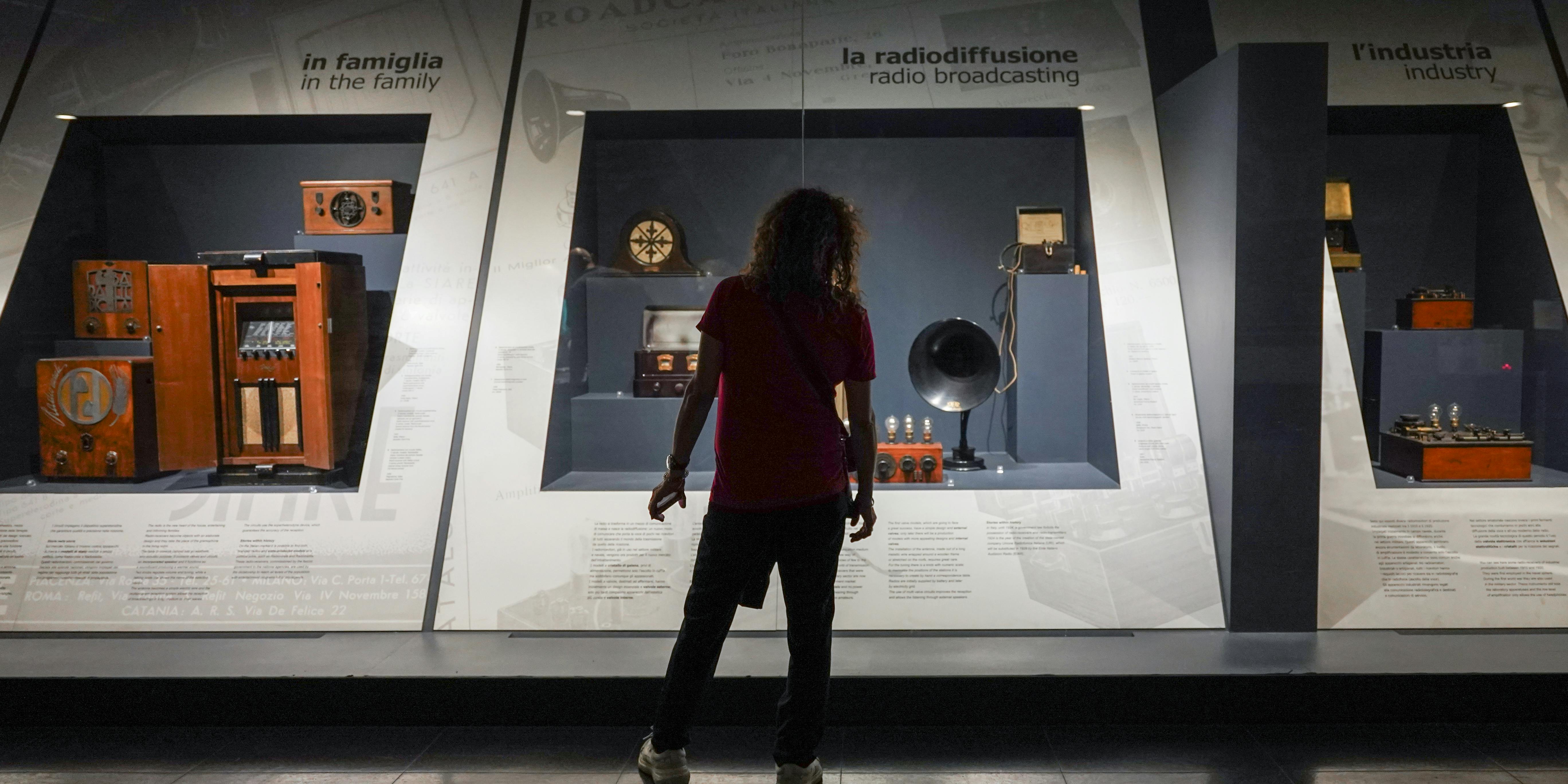 Milano, Museo della Scienza e della Tecnologia Leonardo da Vinci. Esposizione permanente "Telecomunicazioni", sulla storia ed evoluzione dei sistemi di comunicazione. Milano, Museo della Scienza e della Tecnologia Leonardo da Vinci. Esposizione permanente "Telecomunicazioni". Un ragazzo di spalle davanti ad alcuni strumenti di radiodiffusione.