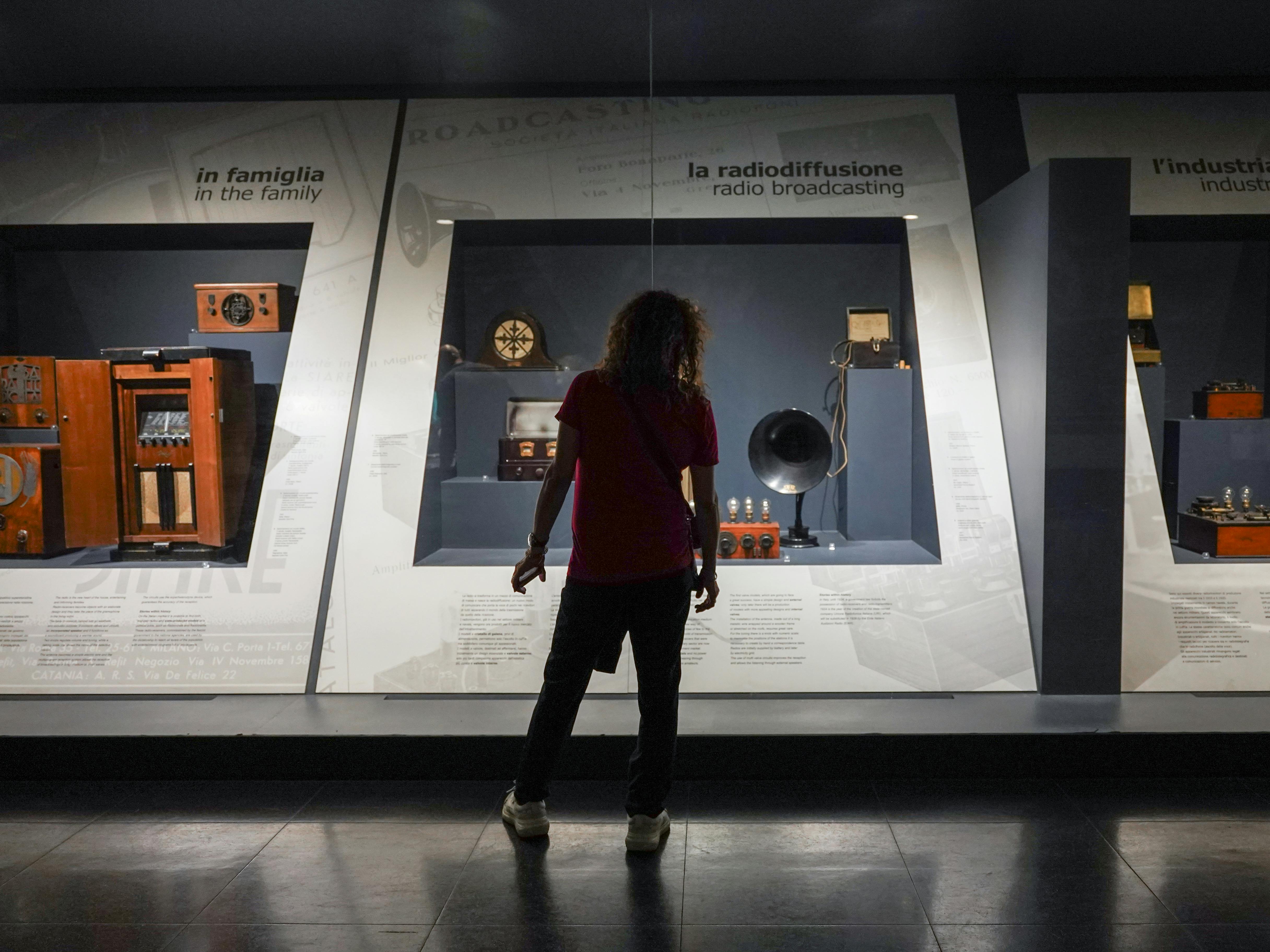 Milano, Museo della Scienza e della Tecnologia Leonardo da Vinci. Esposizione permanente "Telecomunicazioni", sulla storia ed evoluzione dei sistemi di comunicazione. Milano, Museo della Scienza e della Tecnologia Leonardo da Vinci. Esposizione permanente "Telecomunicazioni". Un ragazzo di spalle davanti ad alcuni strumenti di radiodiffusione.