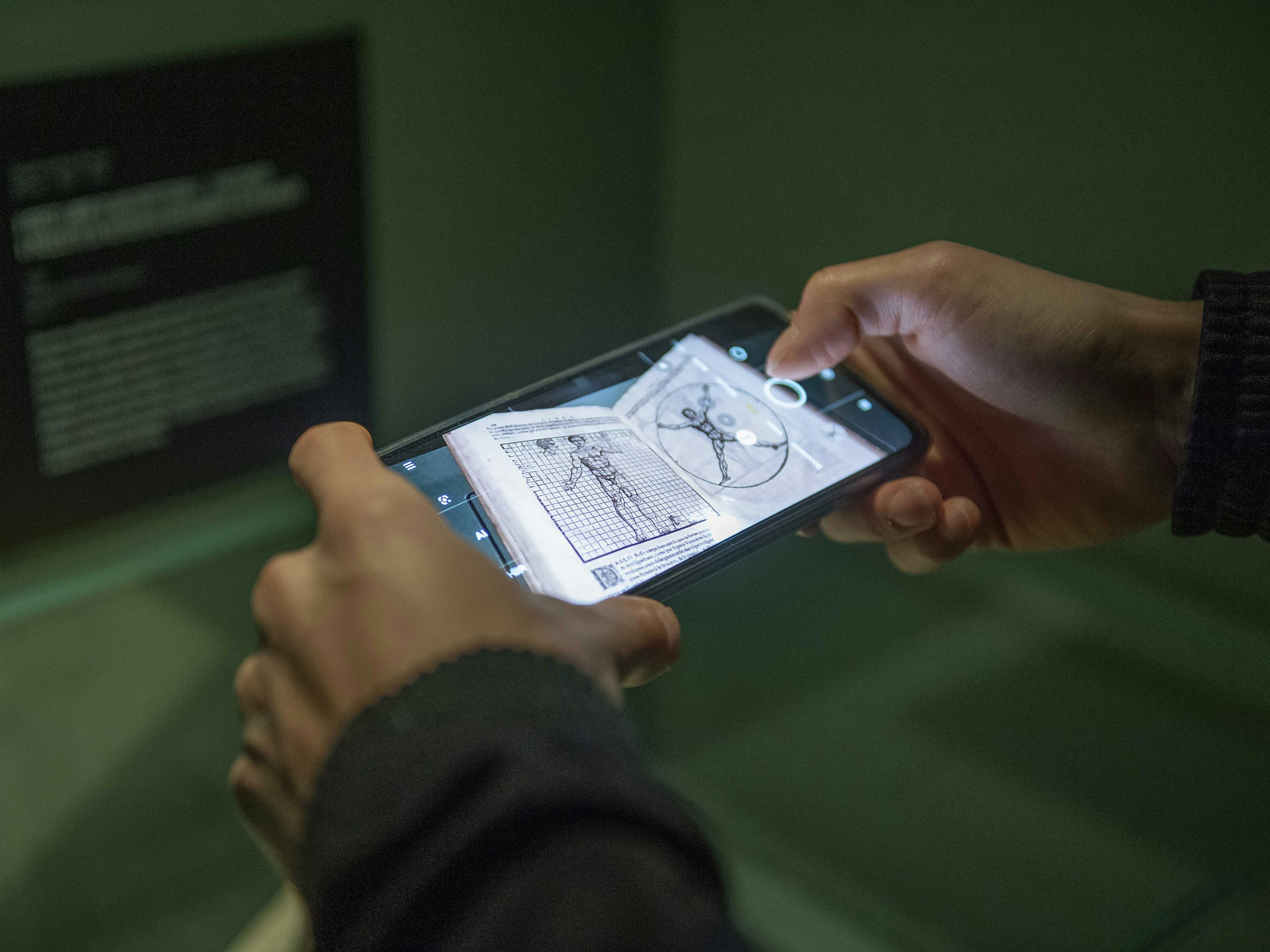 Milano, Museo della scienza e della Tecnologia, Gallerie Leonardo da Vinci. Milano, Museo della scienza e della Tecnologia, Gallerie Leonardo da Vinci. Esplorazione digitale, tramite smartphone, di un libro antico con illustrazioni anatomiche.
