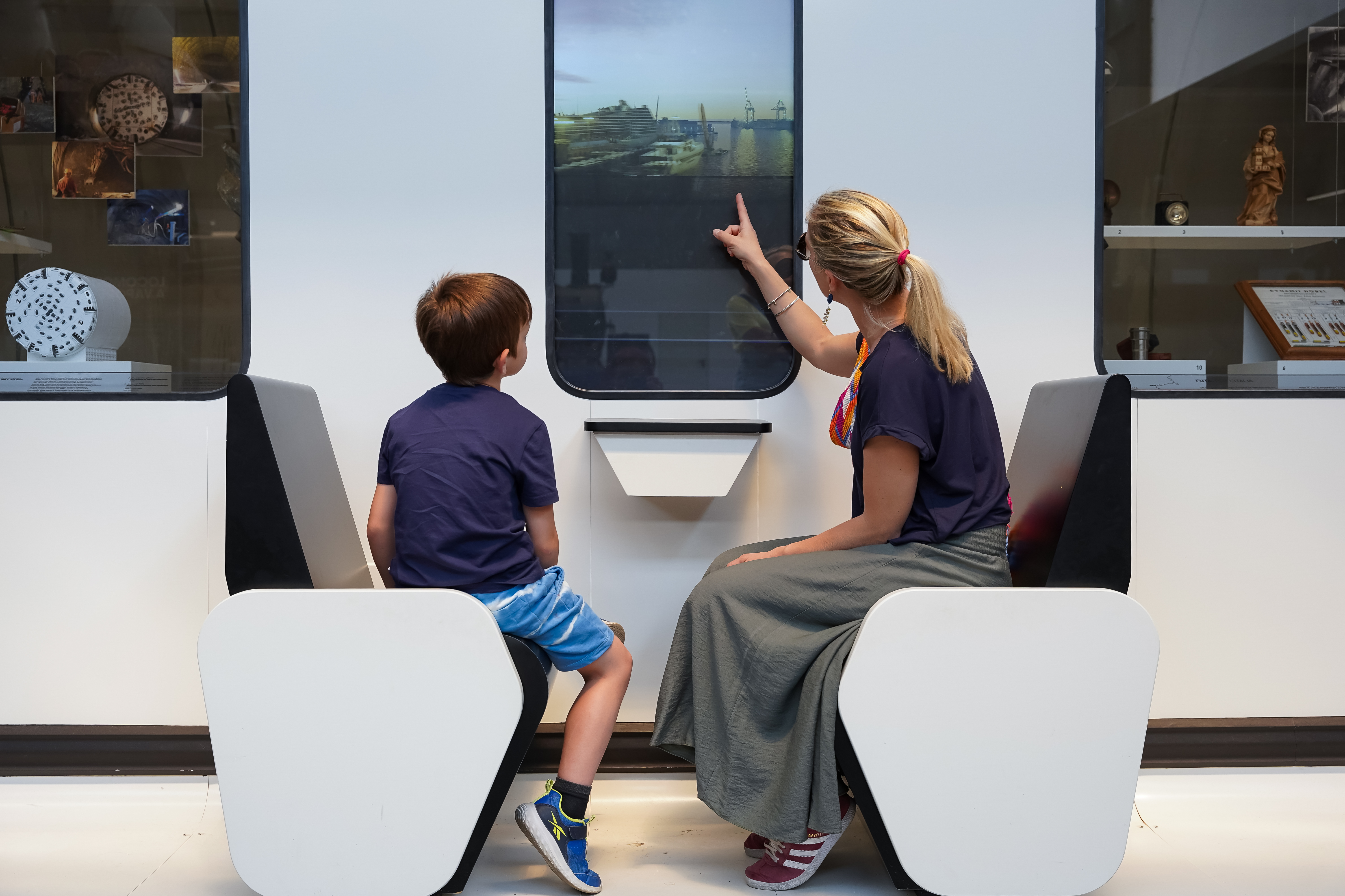 Milano, Museo della scienza e della Tecnologia. Una donna e un bambino guardano attraverso una installazione che simula il finestrino di un treno. Esposizione "Oltrepassare", sulle infrastrutture e sui sistemi di trasporto ferroviari.