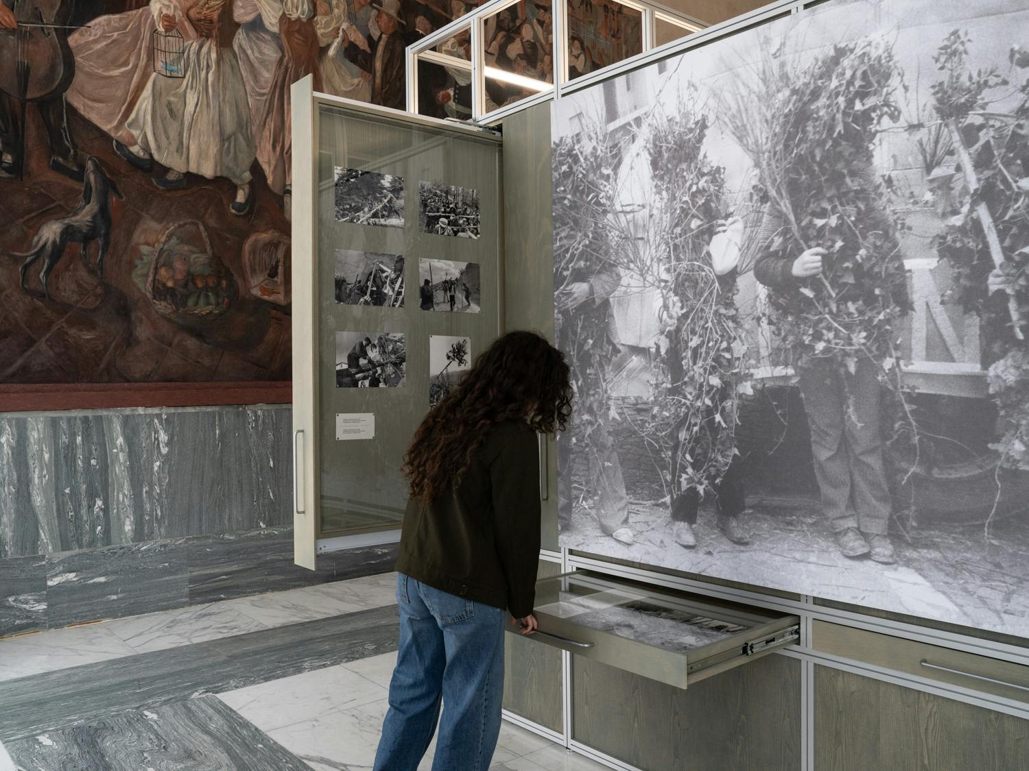 Roma, MUCIV, Museo delle Civiltà. Mostra "Le fiabe sono vere". Una ragazza esplora cassetti espositivi con immagini storiche.