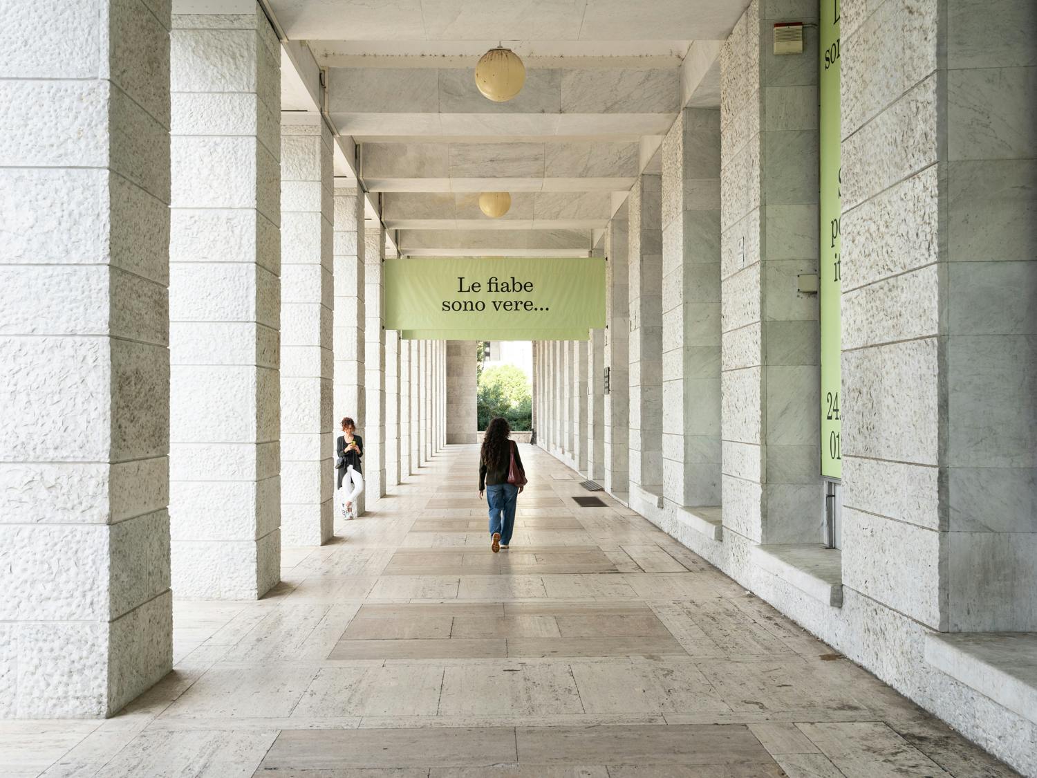 Roma, MUCIV, Museo delle Civiltà. Mostra "Le fiabe sono vere". Roma, MUCIV, Museo delle Civiltà. Mostra "Le fiabe sono vere". Colonnato della sede del museo, con due persone in piedi.