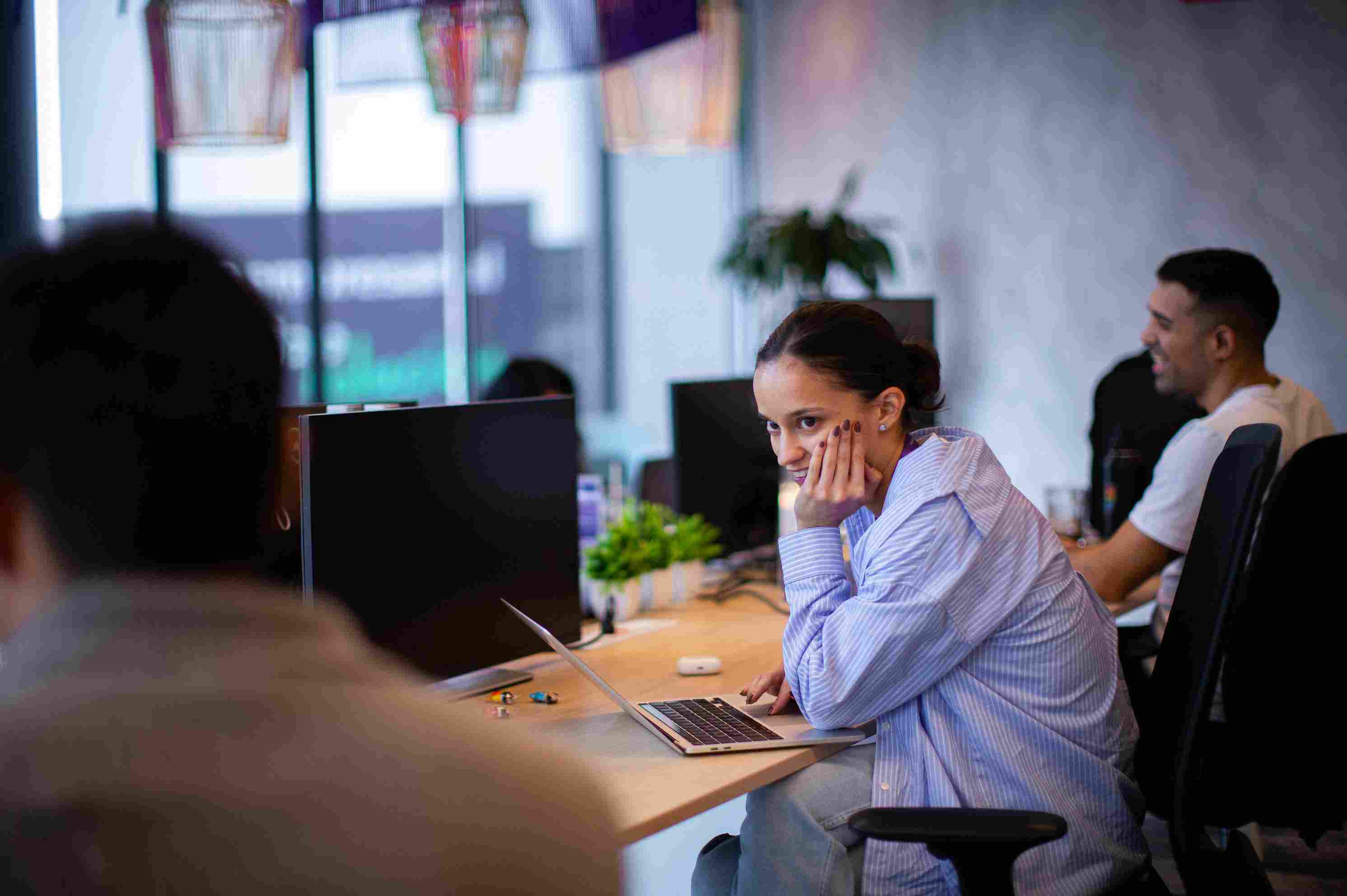 Mujer atenta observa un monitor en un espacio compartido.