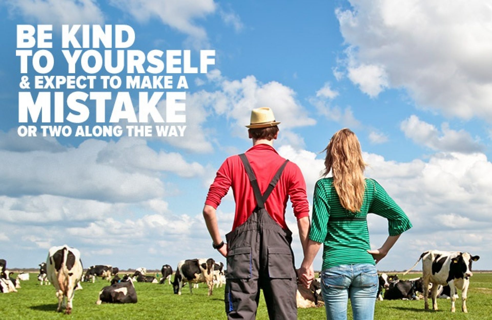 Rancher and wife looking at field of dairy cows