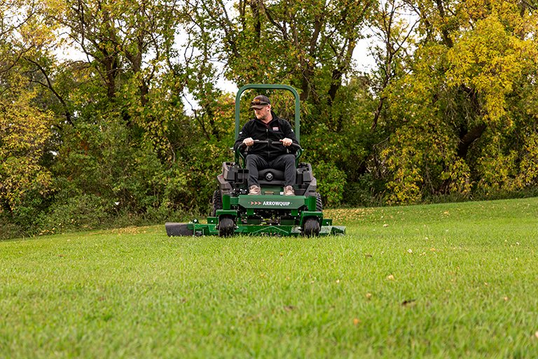 Man mowing lawn on Arrowquip Mowers zero-turn mower built for stability and heavy-duty use