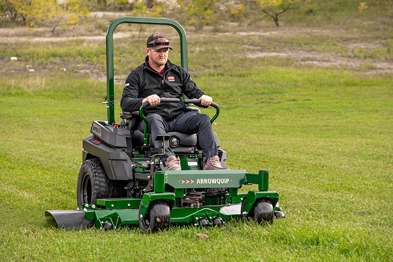 Operator mowing lawn with Arrowquip Mowers zero-turn mower designed for reliable, smooth cuts