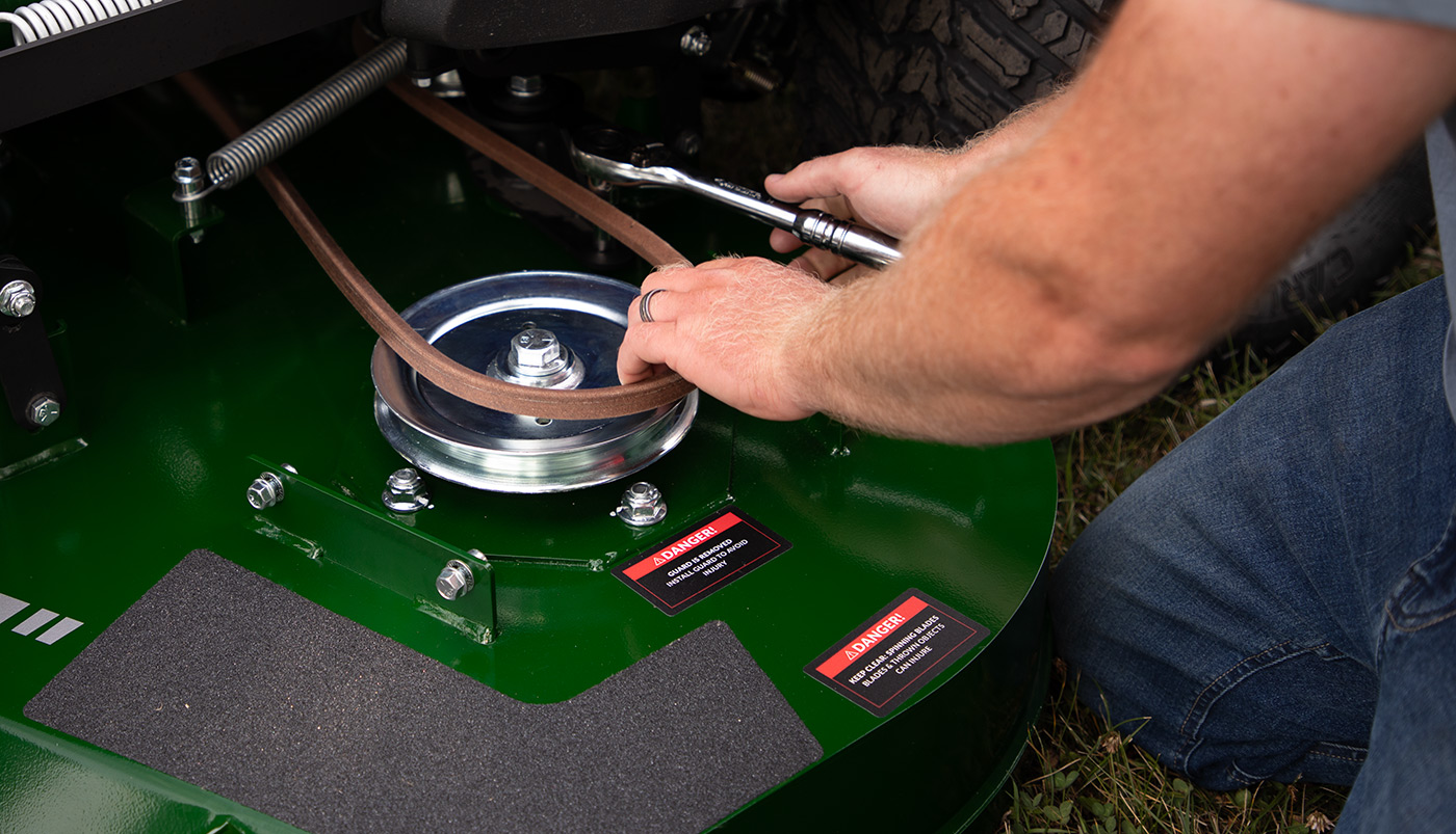 Close-up of Arrowquip Mowers zero-turn mower tensioner arm designed for easy maintenance