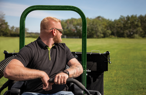Mower operator looking behind him after cutting lawn