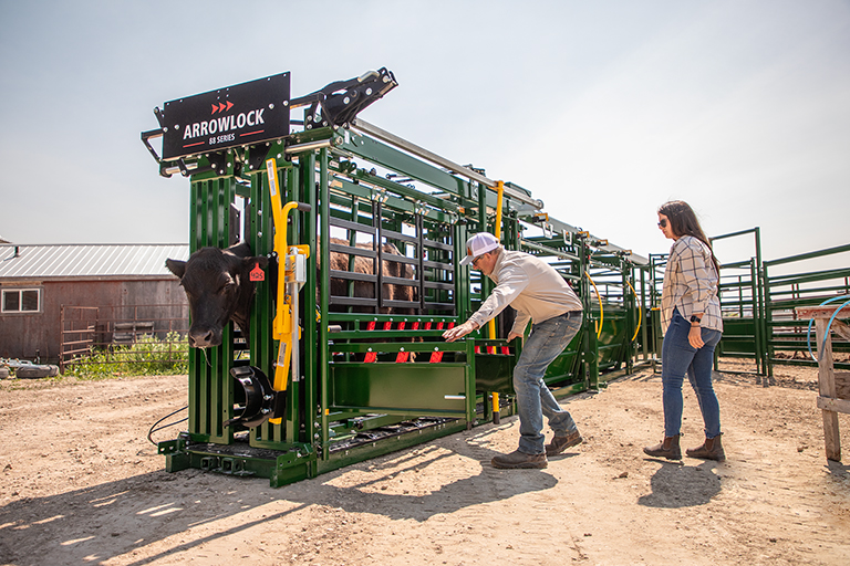 Rancher opening bottom access door on cattle chute