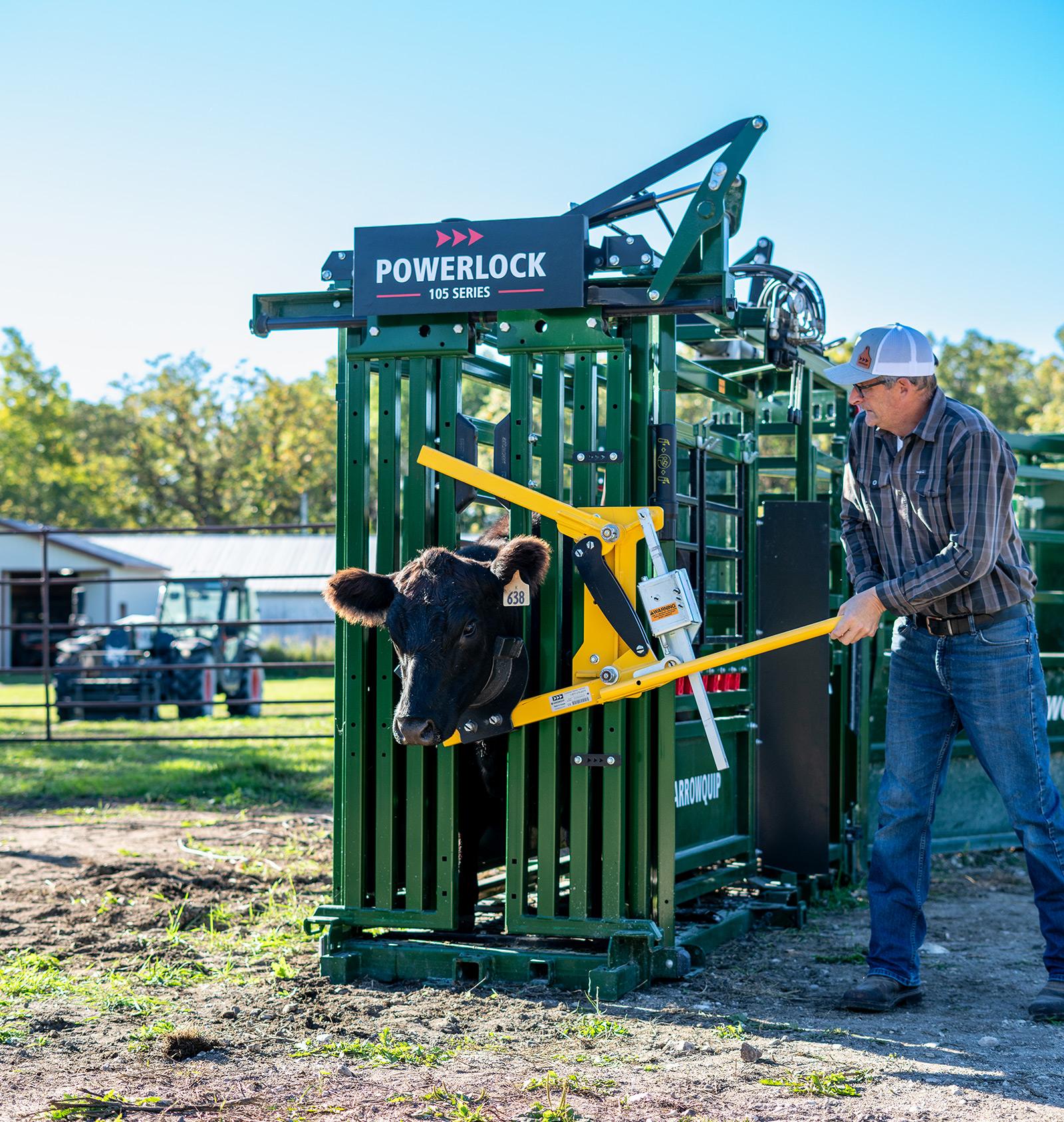 Powerlock 105 series hydraulic squeeze chute with rancher securing black cow in with head holder