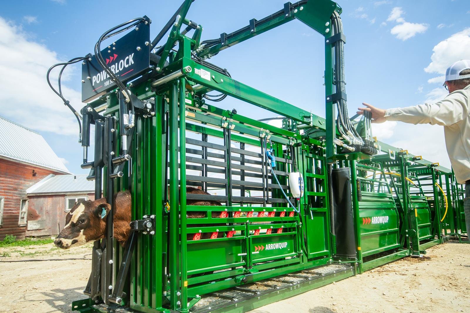 Rancher using effortless hydraulic control on pivoting swing arm of Powerlock 108 series hydraulic cattle chute
