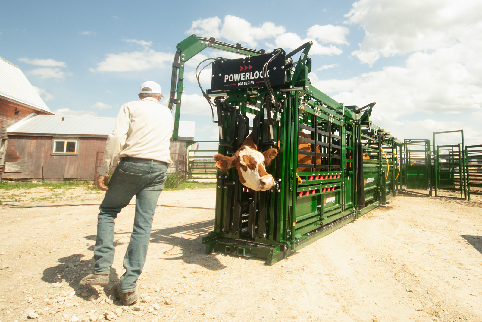 rancher using pivoting control arm on Powerlock 108 series hydraulic cattle chute to work on both sides