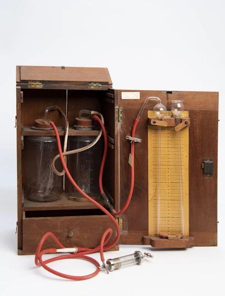 wooden box open holding jars, tubes, syringe and other apperatus