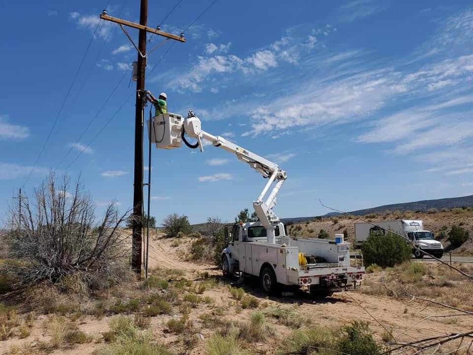 Allied Electric Inc working on Powerlines with bright blue sky