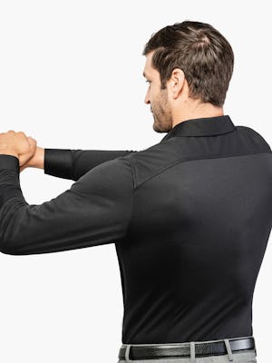Men’s Black Brushed Apollo Dress Shirt model facing backward with arms stretched and hands clasped to the left