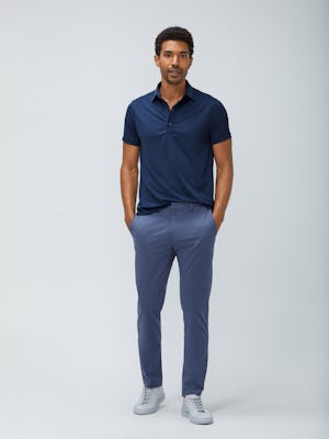 Men's Navy Apollo Polo and Men's Indigo Heather Kinetic Pant on model facing forward with hands in pants pockets