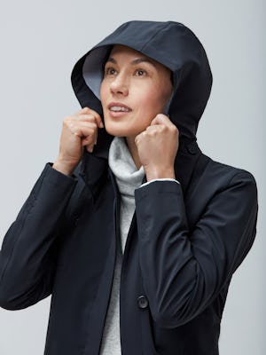 Close up of Women's Marble Hybrid Funnel Neck and Women's Black Doppler Mac on model with hood up