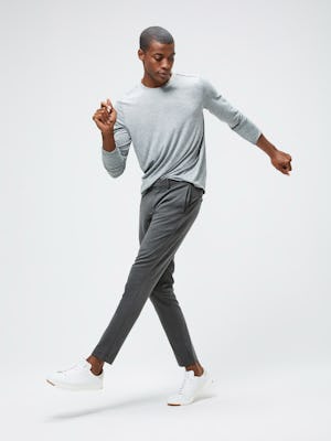 Men's Charcoal Grey Heather Composite Merino Long Sleeve Tee and Men's Graphite Velocity Tapered Pant on model kicking leg up