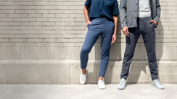 Man and woman standing against a brick wall waring Fusion pants