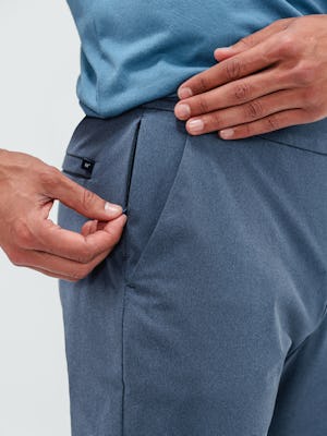 Close up shot of a man zipping up the side pocket of kinetic jogger pants in indigo heather