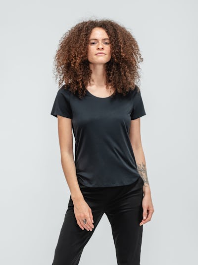 Woman with curly hair wearing black short sleeve luxe touch tee and black kinetic pull on pants