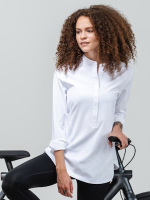 women's white aero zero band collar tunic zoomed shot of model facing forward with bicycle and sleeves rolled up