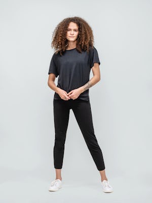 model wearing black composite merino boxy tee and black kinetic pull on pant facing forward with hands clasped