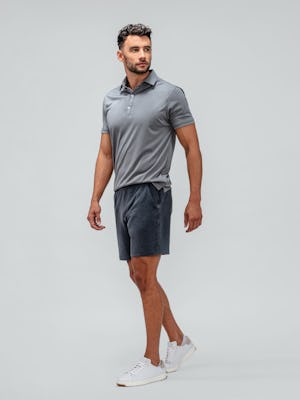 model wearing black oxford apollo polo and dark charcoal fusion terry shorts facing off-center