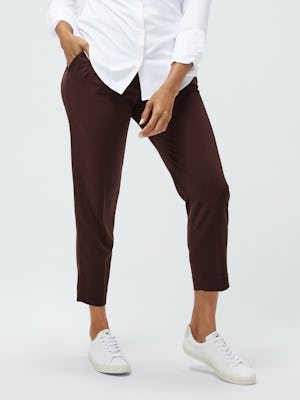 Women's White Aero Zero Carbon Neutral Shirt and Women's Ruby Swift Drape Pant on model facing forward with hand in pocket