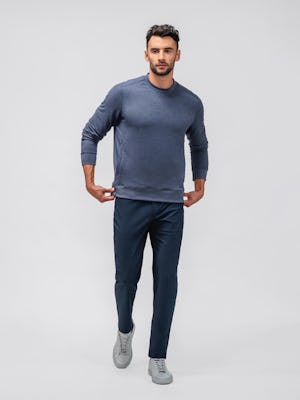 model wearing men fusion terry sweatshirt navy and mens kinetic twill 5 pocket steel blue heather full body holding end of sweatshirt