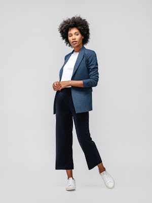 model wearing womens velocity blazer azurite heather and womens swift drape pant navy and womens luxe touch tee white full body left foot out holding hands together