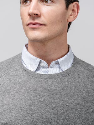 model wearing men's grey heather stripe hybrid button-down and medium grey atlas merino crew neck sweater close up of collar