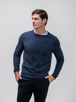 model wearing men's navy kinetic tapered pant and indigo atlas merino crew neck sweater facing forward with hands in pockets