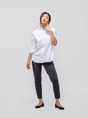 model wearing women's charcoal kinetic pull on pant and white aero zero oversized shirt standing one hand on collar